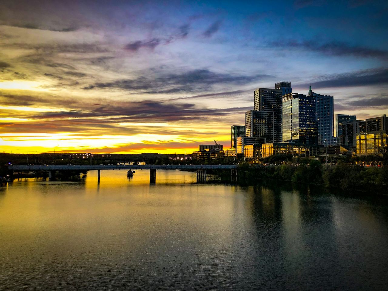 Downtown Austin skyline and a bridge over Lady Bird Lake at sunset